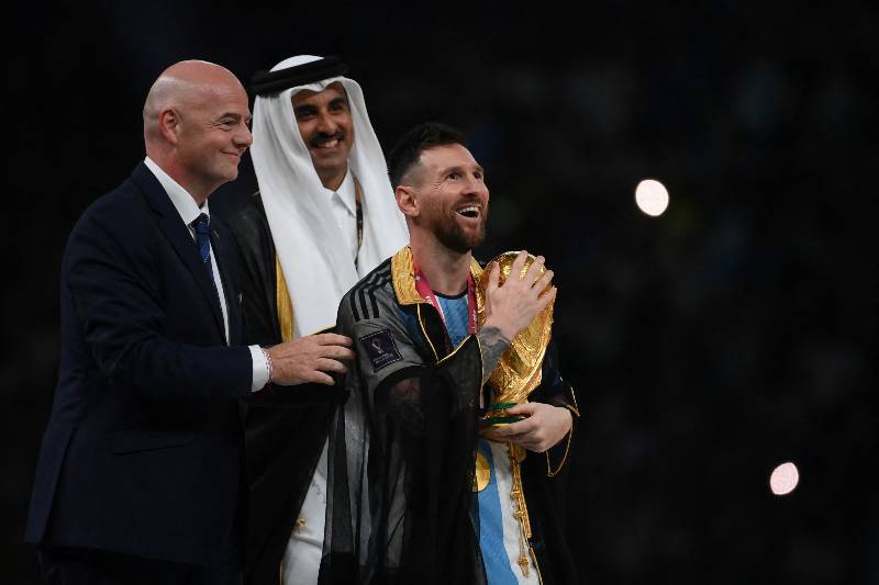 El jeque Tamim bin Hamad Al Thani le impuso la túnica sobre los hombros antes de tomar el trofeo de la Copa del Mundo.