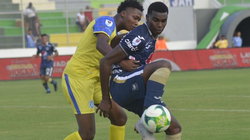 El debutando del Motagua Aarón Barrios cubre el balón ante la presión de Maynor Colón.