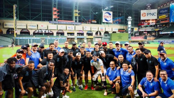 El pelotero hondureño Mauricio Dubón posa con los integrantes de la Selección Nacional en el diamante del Minute Park.