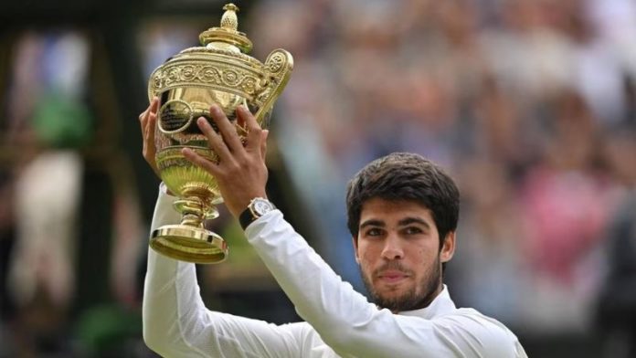 El español Carlos Alcaraz levanta el trofeo como campeón en Wimbledon.