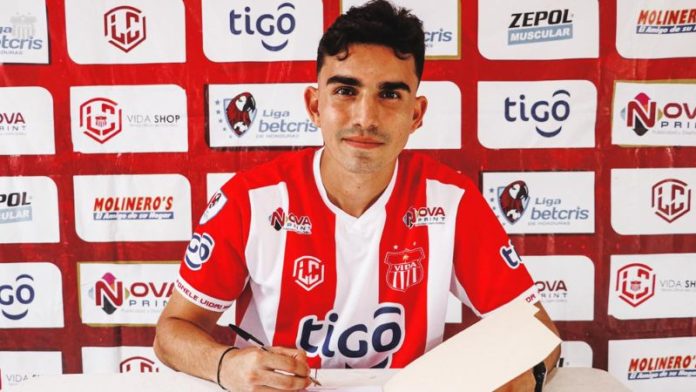 El joven mediocampista Carlos "Charlie" Estrada firma el contrato que lo liga al equipo Vida de La Ceiba.