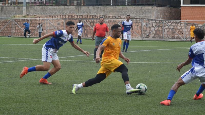 Carlos Róchez de Lobos UPNFM conduce el balón marcado por dos defensas del Atlético Junior.