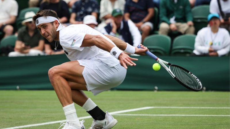 El argentino Tomás Etcheverry devuelve una bola durante su derrota ante el suizo Stan Wawrinka en la segunda ronda de Wimbledon.