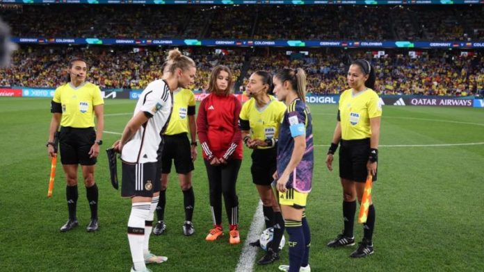 Melissa Pastrana al momento de la rifa de cancha del partido Alemania vs Colombia . Atrás su compatriota Shirley Perelló.