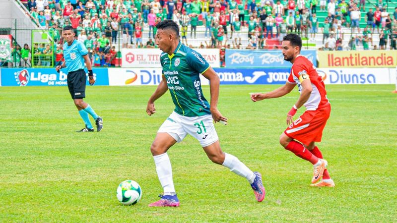 El marathonista Allan Banegas conduce el balón ante la mirada del ceibeño Marcelo Canales.