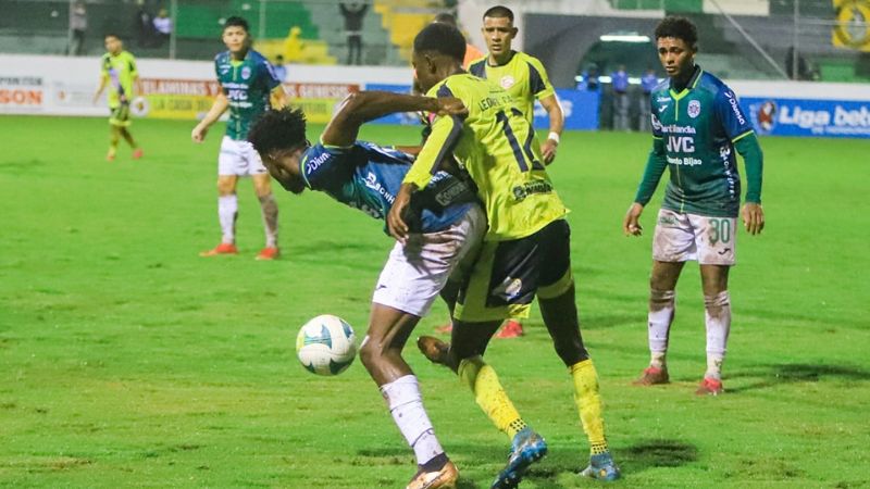 Cristian Sacaza, del Marathón, cubre el balón ante la marca de Leonel Casildo, del Génesis Comayagua.