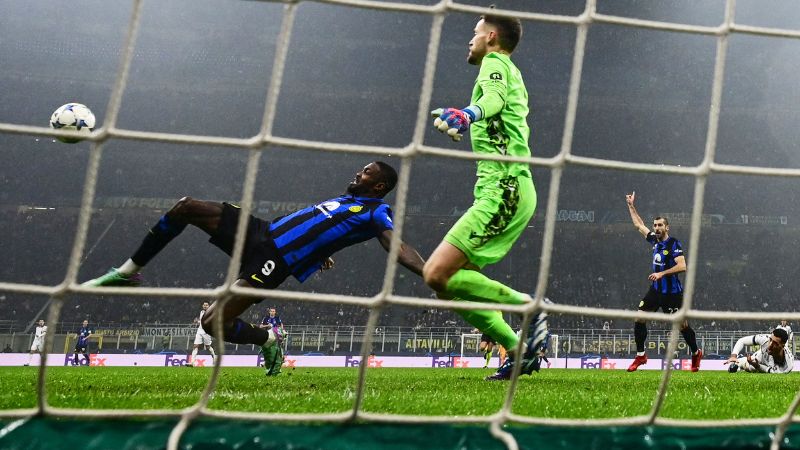El delantero francés del Inter de Milán #09 Marcus Thuram (L) dispara el balón durante el partido de fútbol del Grupo D.
