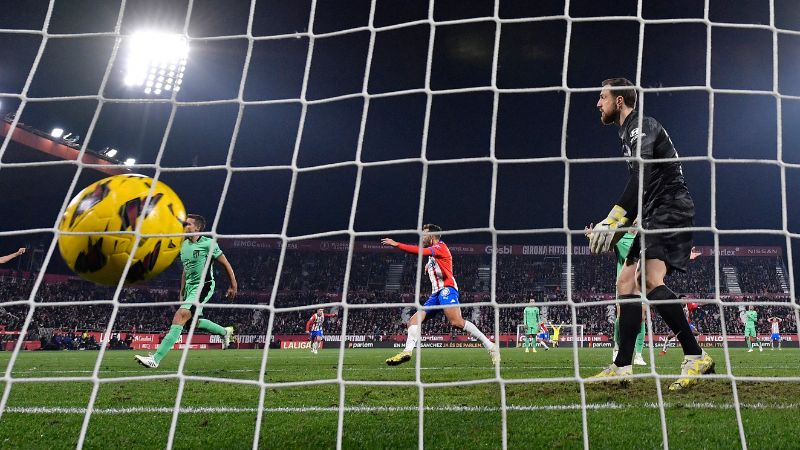 El mediocampista español de Girona Iván Martin anota el cuarto gol de su equipo al superar al portero esloveno del Atlético de Madrid, Jan Oblak.