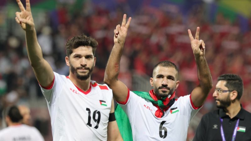 El delantero palestino (19) Mahmoud Wadi y el centrocampista palestino (6) Oday Kharoub saludan a sus seguidores después del partido contra Hong Kong.
