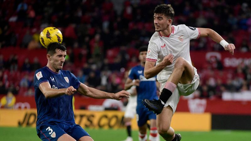 El defensor español del Sevilla, Kike Salas, compite con el defensor español del Athletic de Bilbao, Dani Vivian.