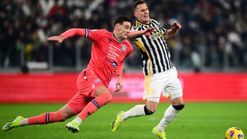 En la gráfica, el delantero italiano del Udinese, Lorenzo Lucca, lucha por el balón con el delantero polaco de la Juventus, Arkadiusz Milik.
