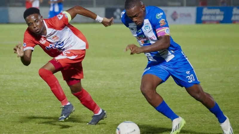 El delantero colombiano del Victoria, Luis Hurtado, conduce el balón ante la mirada de Marvin Bernárdez, de Vida.