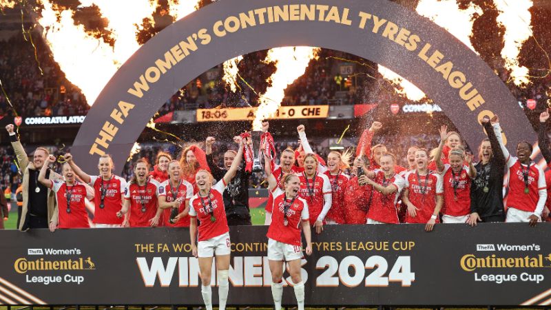 Las jugadoras del Arsenal Leah Williamson (centro izquierda) y Kim Little (centro derecha) sostienen el trofeo de campeón de la Copa de la Liga Femenina inglesa.