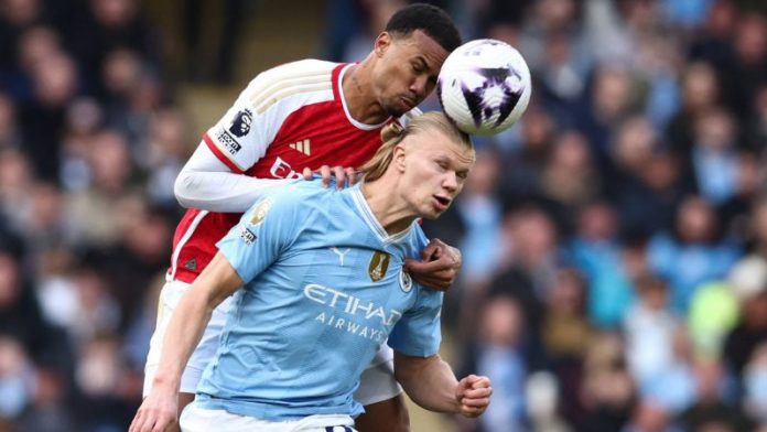 El defensor brasileño del Arsenal, Gabriel Magalhaes, lucha por el balón con el delantero noruego del Manchester City, Erling Haaland.