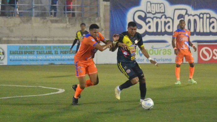 Jack Baptiste, de Lobos UPNFM, y Sergio Peña, de Génesis Comayagua, disputan el balón.