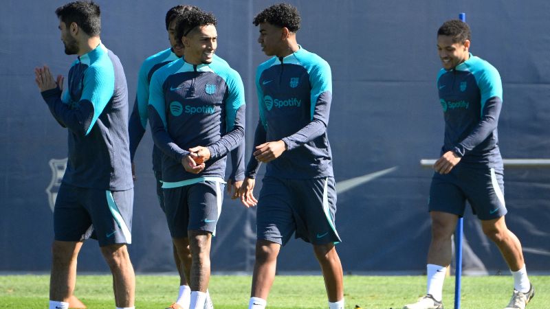 El delantero brasileño del Barcelona, Raphinha y el delantero español del Barcelona, Lamine Yamal, conversan mientras asisten a una sesión de entrenamiento.
