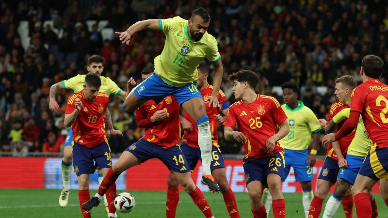 El zaguero brasileño Fabricio Bruno salta por el balón junto al defensor español Pau Cubarsi.