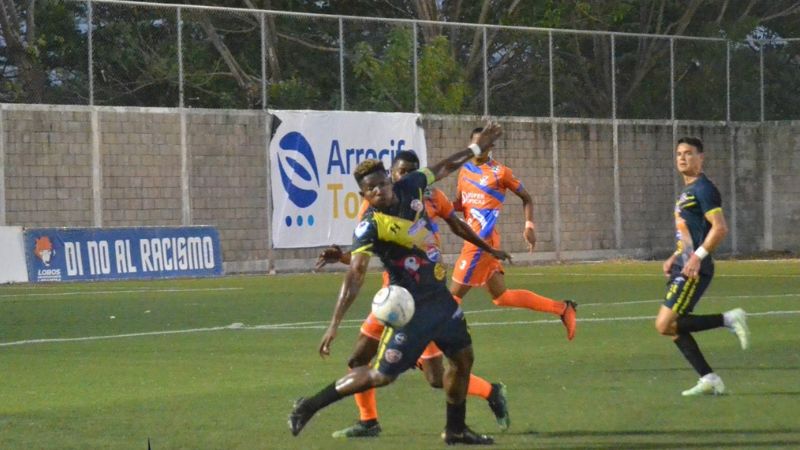 El delantero de Génesis Comayagua, Franco Guity, cubre el balón ante la presión del defensa de Lobos UPNFM, Robel Bernárdez.