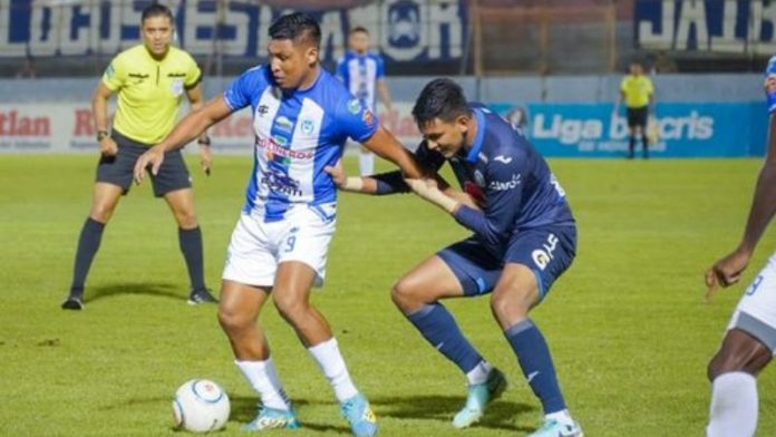 El delantero de Victoria, Frelys López, es presionado por el defensa de Motagua, Luis Vega.