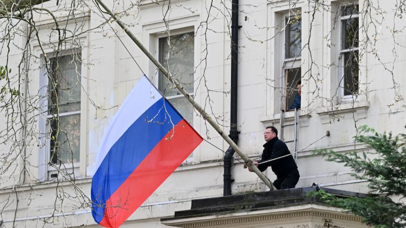 Una persona ajusta la bandera nacional de Rusia, ondeando a media asta, frente a la embajada rusa en Londres el 23 de marzo de 2024.