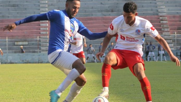 El defensa de Victoria, José Danilo Tobías, llega a la marca del olimpista, José Mario Pinto.