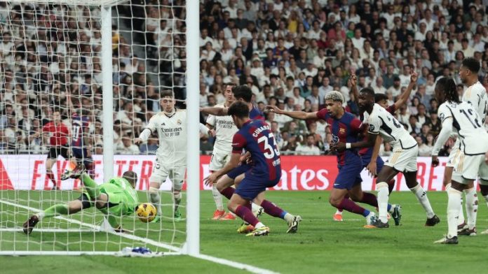 El portero ucraniano del Real Madrid Andriy Lunin se zambulle para quedarse con el balón.