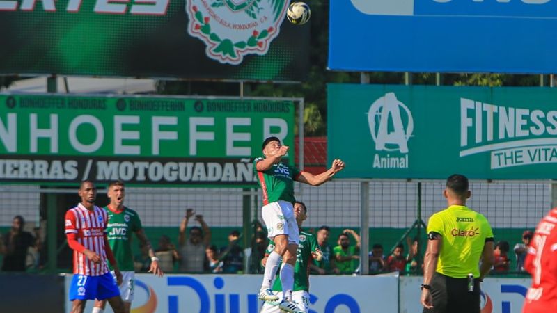 El volante de contención de Marathón, Francisco Martínez, salta por el balón.