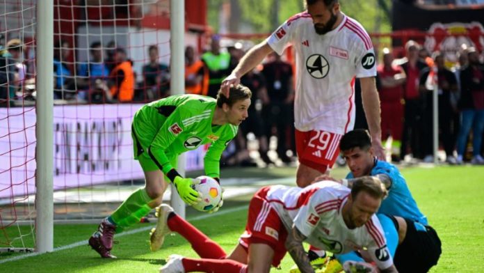 El portero danés del Union Berlin, Frederik Ronnow, salva el balón durante el partido contra el Bayer Leverkusen.