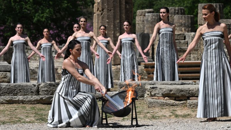 La actriz griega Mary Mina, interpretando el papel de la Suma Sacerdotisa, enciende la antorcha durante el ensayo de la ceremonia de encendido de la llama de los Juegos Olímpicos de París 2024 en el antiguo templo de Hera.
