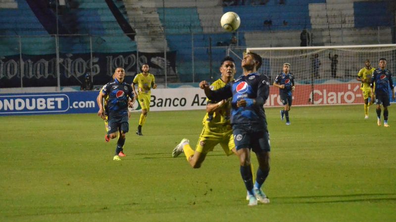El defensa de Motagua, Luis Vega, es presionado por el delantero de Génesis Comayagua, Roberto Moreira.