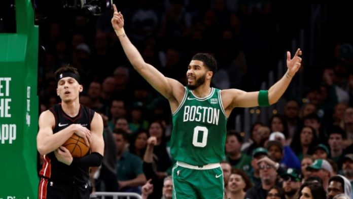 Jayson Tatum (derecha), de los Boston Celtics, protesta junto a Tyler Herro, de los Miami Heat.