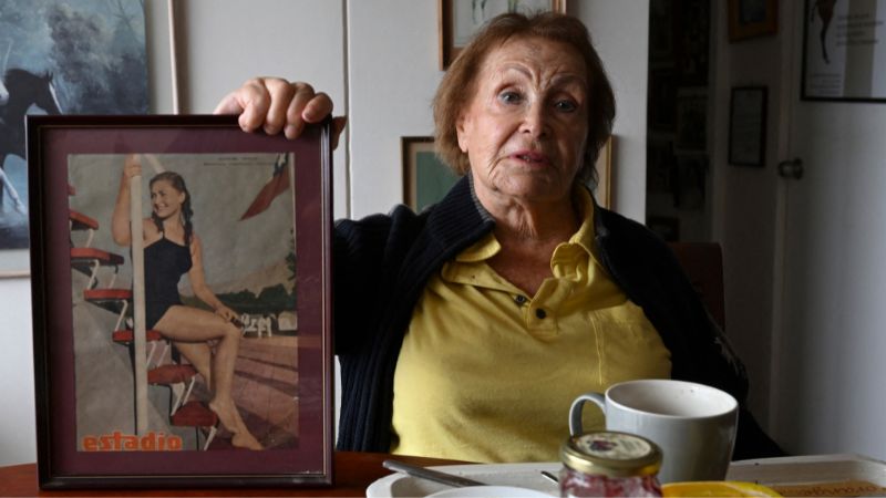 La nadadora chilena Eliana Busch, de 89 años, muestra un viejo recorte de periódico durante una entrevista con la AFP en Viña del Mar, Chile.