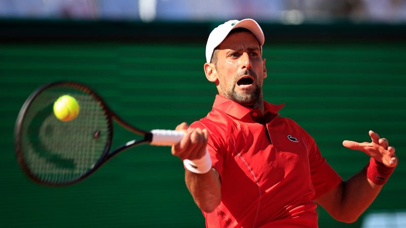 El serbio Novak Djokovic juega un regreso de derecha al italiano Lorenzo Musetti .