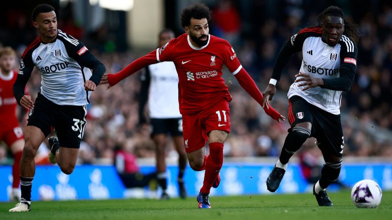 El delantero egipcio del Liverpool, Mohamed Salah, compite por el balón con los jugadores del Fulham, Antonee Robinson y Calvin Bassey.