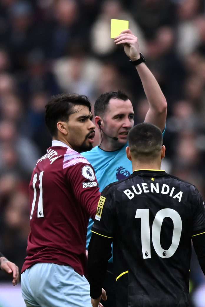 En la foto de archivo, el árbitro inglés Chris Kavanagh muestra una tarjeta amarilla al mediocampista brasileño del West Ham United, Lucas Paquetá.