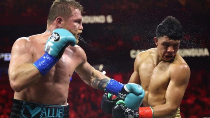 Saúl "Canelo" Álvarez conecta un golpe de izquierda en el rostro de su compatriota mexicano Jaime Munguía en la pelea por los títulos supermedianos.