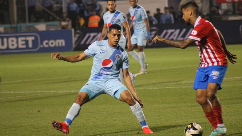 El volante de Motagua, Denis Meléndez, llega a la marca del brasileño de Olimpia, Gabriel Araujo.