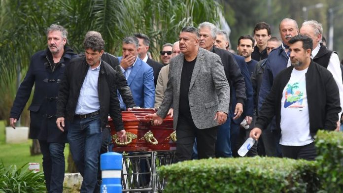 El presidente de la Asociación de Fútbol Argentino (AFA), Claudio Tapia, familiares, amigos y otros miembros de la AFA llevan el féretro del fallecido entrenador ​​César Menotti.