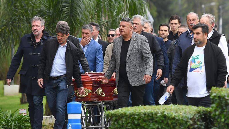 El presidente de la Asociación de Fútbol Argentino (AFA), Claudio Tapia, familiares, amigos y otros miembros de la AFA llevan el féretro del fallecido entrenador ​​César Menotti.