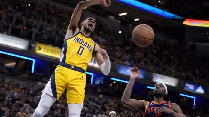 Tyrese Haliburton (0), de los Pacers de Indiana, retaca el balón ante la mirada de Precious Achiuwa, de los Knicks de Nueva York.