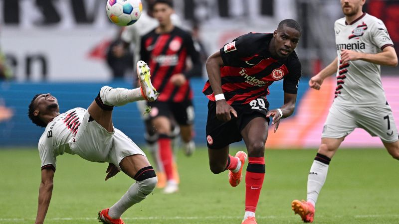 El centrocampista inglés del Bayer Leverkusen, Nathan Tella, compite por el balón con el defensor francés de Frankfurt, Niels Nkounkou.