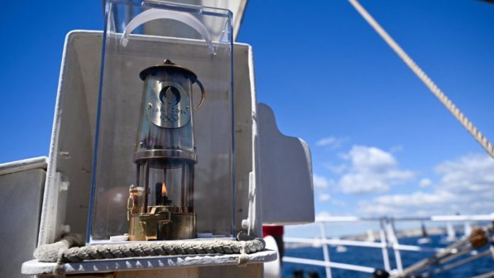 Esta fotografía muestra la llama olímpica en la barca francesa Belem de tres mástiles del siglo XIX .