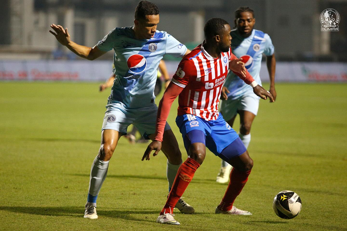 El defensa de Motagua, Carlos Meléndez, llega a la marca del colombiano de Olimpia, Yustin Arboleda.