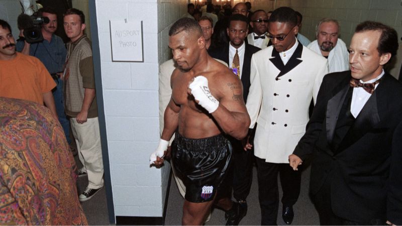 En la foto de archivo, el estadounidense Mike Tyson levanta el puño en señal de victoria mientras regresa a su vestuario después de derrotar a Peter McNeeley el 19 de agosto de 1995.