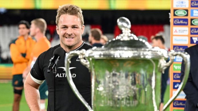 Sam Cane de Nueva Zelanda posa junto al trofeo después de ganar el Campeonato de Rugby.