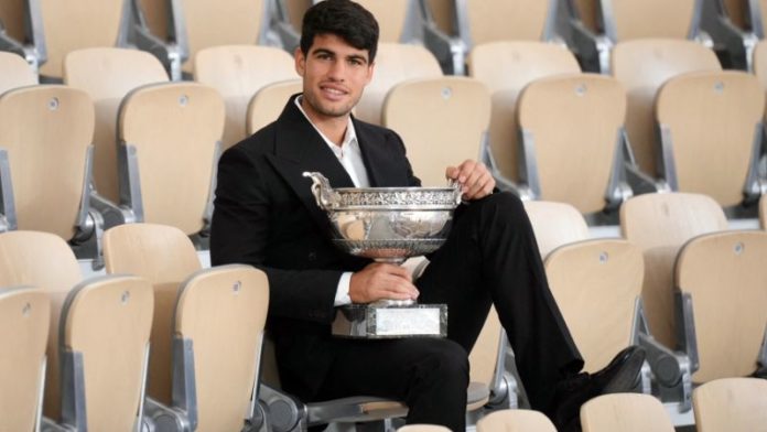 El español Carlos Alcaraz posa con su trofeo un día después de ganar el torneo de tenis del Abierto de Francia en el complejo Roland Garros de París.