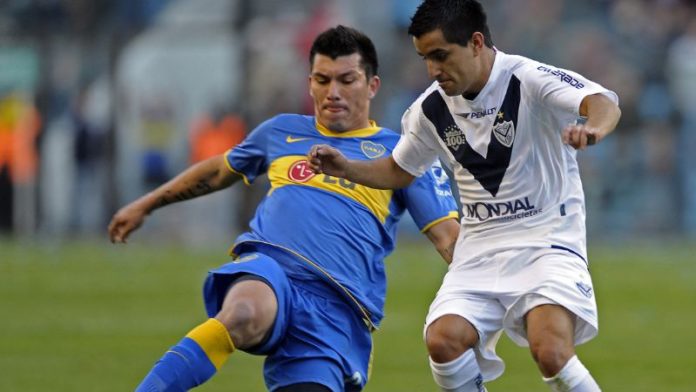 En la foto de archivo, el mediocampista chileno de Boca Juniors, Gary Medel, pelea por el balón con el volante de Vélez Sarsfield, Maximiliano Morales.