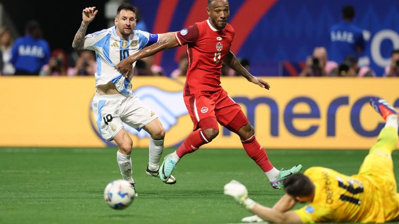 El delantero argentino Lionel Messi dispara, pero no logra anotar mientras lucha por el balón con el portero canadiense, Maxime Crepeau, y el defensor Derek Cornelius.