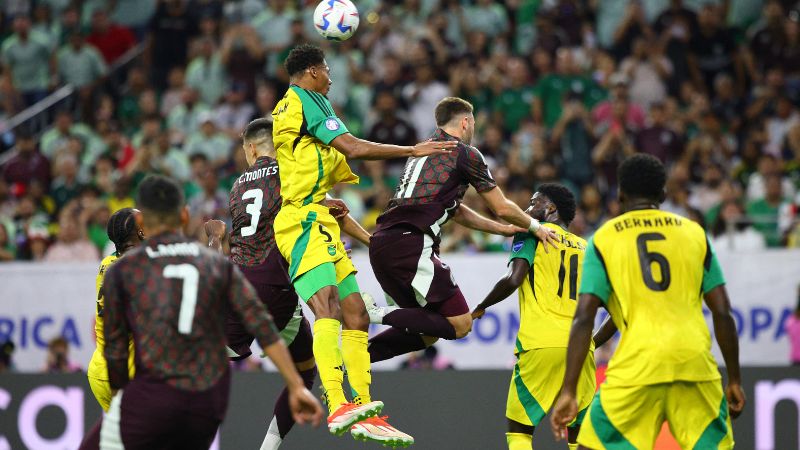 El defensor de Jamaica, Ethan Pinnock, aleja el balón de cabeza presionado por el mexicano, Santiago Giménez.