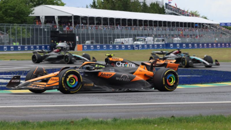 El piloto británico de McLaren, Lando Norris (frente), corre por delante del piloto británico de Mercedes, George Russell (derecha, atrás) y del piloto Lewis Hamilton.